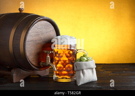 Vintage Barrel Bier mit riesigen Glas Bier und sackleinen Beutel mit frischem Hopfen auf hölzernen Tisch noch Leben Stockfoto