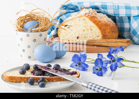 Ostern Frühstück oder Brunch Tabelle in Blau gehalten, mit Ostern Symbolen verziert, traditionelle tschechische Ostern Gebäck Mazanec, Pomlazka und Eier. Stockfoto