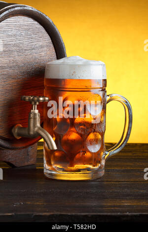 Vintage Barrel Bier mit riesigen Bier Glas auf hölzernen Tisch noch leben Nahaufnahme Stockfoto