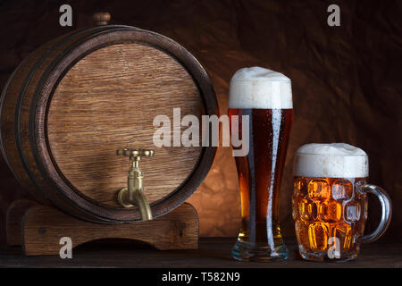 Barrel Bier mit zwei Bier Gläser auf hölzernen Tisch dunkel, Still-life Stockfoto