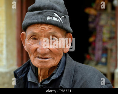 Alte Han-chinesische Farm hand mit lebte - Gesicht eine Wollene Skull Cap trägt und posiert für die Kamera. Stockfoto