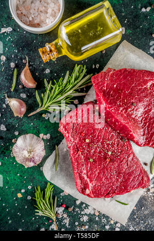 Rohes Rindfleisch Fleisch Steaks mit Gewürzen und Kräutern, dunkle konkreten Hintergrund Kopie Raum Stockfoto