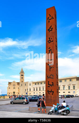 Trani Apulien/Italien - 2014/08/24: modernistische Obelisk Dekoration an der Piazza Re Manfredi Platz mit Dom St. Nikolaus die Pilger in zurück Stockfoto