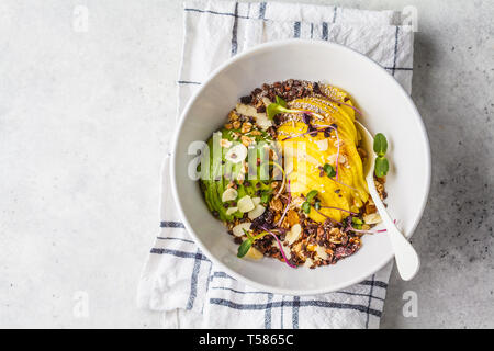 Müsli mit Avocado, Superfoods, Beeren und Früchte in einer weißen Schüssel. Auf Basis pflanzlicher Ernährung Konzept. Stockfoto