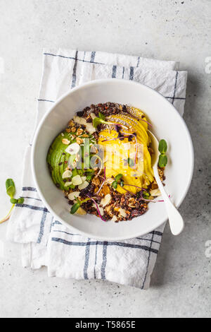 Müsli mit Avocado, Superfoods, Beeren und Früchte in einer weißen Schüssel. Auf Basis pflanzlicher Ernährung Konzept. Stockfoto