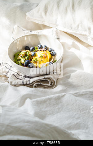 Müsli mit Avocado, Superfoods, Beeren und Früchte in einer weißen Schüssel. Auf Basis pflanzlicher Ernährung Konzept. Stockfoto