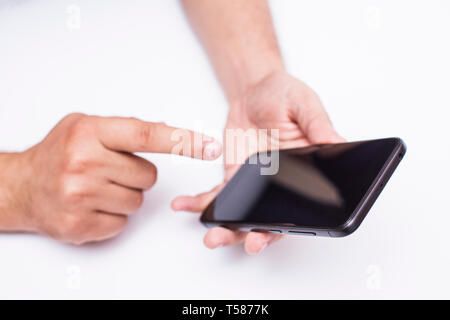 Blick von oben auf die Hände halten ein Handy Stockfoto