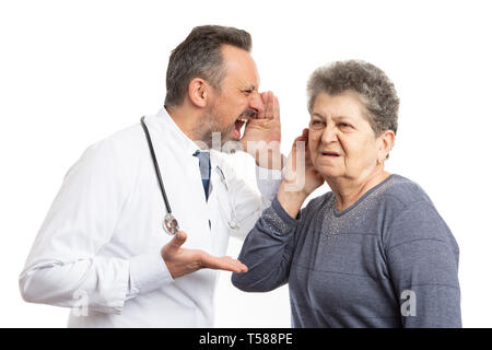 Wütend männlicher Arzt rufen bei älteren gehörlosen Patienten Ohr mit der Hand in der Nähe der geöffneten Mund auf weißem studio Hintergrund isoliert Stockfoto