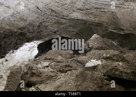 Hälfte - mit Rock und Lehm natürliche Höhle gefüllt. Nach dem Zusammenbruch der Tropfsteinhöhle, Steinschlag. Stockfoto