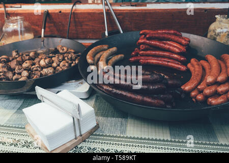 Street Food auf dem traditionellen Weihnachtsmarkt in der Tschechischen Republik, gebratene Würstchen Stockfoto