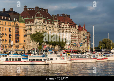 Am späten Nachmittag Sonne leuchtet die Fähren auf Ladugårds - landsviken flankiert vom Hotel Esplanade, Hotel Diplomat und dem großen Gebäude der Strandvägen Stockfoto