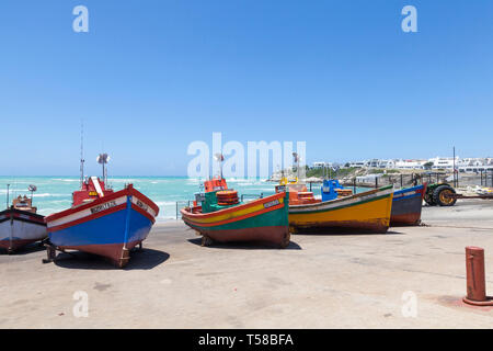 Malerische Fischerdorf Arniston, Agulhas, Western Cape, Südafrika, bunte traditionelle hölzerne Fischerboote im Hafen an Land an einem windigen Stockfoto