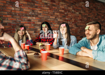 Lächelnd Freunde spielen Aufkleber Hinweise an die Stirn Stockfoto