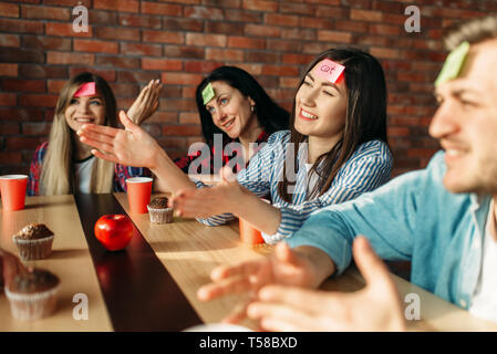 Lächelnd Freunde spielen Aufkleber Hinweise an die Stirn Stockfoto