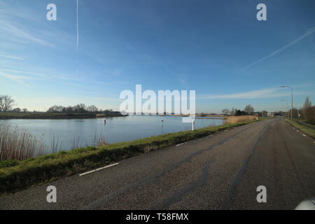 Blauer Himmel und Sonne über den Fluß Hollandsche IJssel bei Moordrecht in den Niederlanden Stockfoto