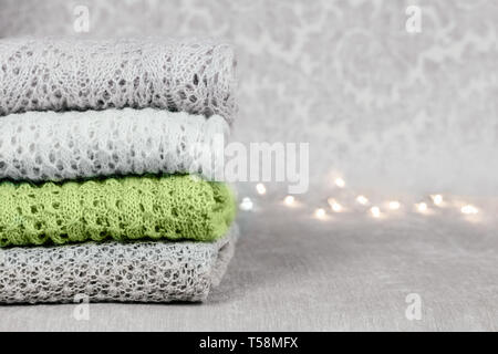 Stilvolle gestrickt, pastellfarbenen Pullover und eine in trendigen Farben der Frühling und Sommer 2019 in auf Samtigen Stoff Hintergrund stack gefaltet. Stockfoto