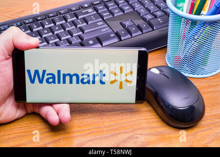 PIATRA Neamt, Rumänien - 13. APRIL 2019: Hand hält die neue Huawei Flaggschiff, P30 Pro, mit Walmart Corporation auf dem Bildschirm, Büro Hintergrund. Stockfoto