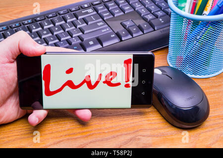 PIATRA Neamt, Rumänien - 13. APRIL 2019: Hand hält die neue Huawei Flaggschiff, P30 Pro, mit Live-Symbol auf dem Bildschirm, Büro Hintergrund. Stockfoto