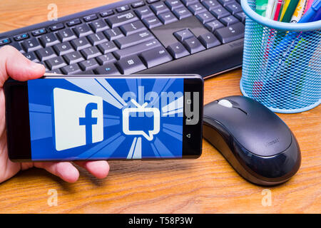 PIATRA Neamt, Rumänien - 13. APRIL 2019: Hand hält die neue Huawei Flaggschiff, P30 Pro, mit Facebook Watch auf dem Bildschirm, Büro Hintergrund. Stockfoto