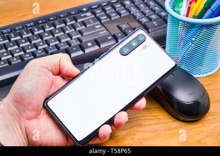 PIATRA Neamt, Rumänien - 13. APRIL 2019: Hand hält die neue Huawei Flaggschiff, P30 Pro mit Büro Hintergrund. Stockfoto