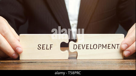 Geschäftsmann sammelt Rätsel mit dem Wort selbst-Entwicklung. Konzept der neuen unternehmerischen Fähigkeiten und Motivation. Beruflichen und persönlichen Wachstum. Self-improveme Stockfoto