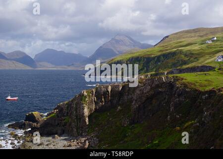 Kleine rote Fischerboot im Loch Scavaig in Elgol, durch die schroffen Cullin Hills. Isle of Skye, Schottland, Großbritannien. Stockfoto