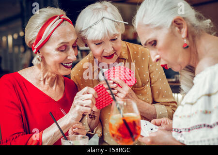 Freudige schön gealterte Frauen poker spielen zusammen Stockfoto