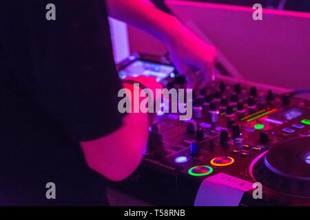 DJ auf Plattenspieler spielen elektronische Musik in dunklen Nachtclub in der Stadt Stockfoto