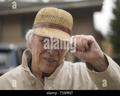 Outdoor Portrait Of Happy älterer Mann mit Strohhut und Sagen hallo Stockfoto