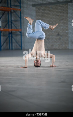 Ein athletischer Mann auf capoeira Training. Stehend auf die Hände in der Pose Stockfoto