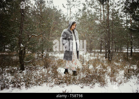 Winter Frau steht im Wald Stockfoto