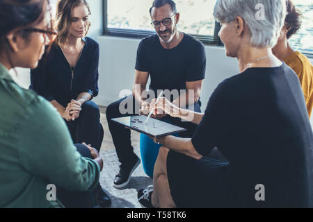 Multi-ethnischen Gruppe von Menschen sitzen zusammen in eine Diskussion in der Gruppe. Geschäftsleute in einer Sitzung über die neue Strategien. Stockfoto