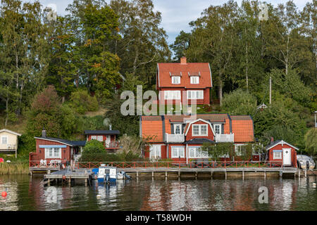 Ein Weiler der traditionellen bunten hölzernen Sommerhäuser auf Skarpö in den Stockholmer Schären. Stockfoto