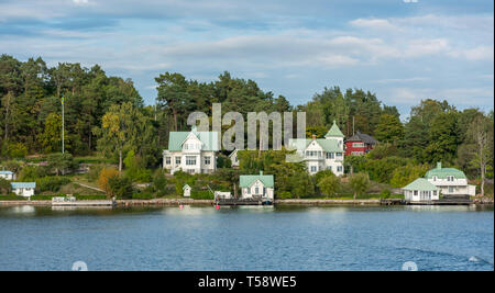 Traditionelle grün - überdachte Holzhäuser auf Stegesund Insel in den stockholmer Schären. Stockfoto