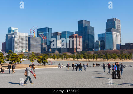 Touristen am Kokyo Gaien National Garden Plaza mit hohen Bürogebäuden der Marunouchi business, Bezirk im Hintergrund. Tokio, Japan. Stockfoto