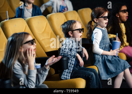 Aufgeregt multikulturellen Freunde in 3D-Brille ansehen Film im Kino. Stockfoto