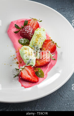 Frersh Erdbeeren mit Schlagsahne, Speiseeis und Puderzucker. Stockfoto