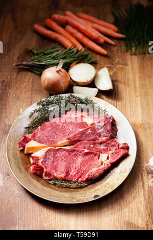 Rohes Rindfleisch geht mit Kräutern und frischem Gemüse fertig gegrillt zu werden. Geheime Zutat. Natürliches protein. Stockfoto
