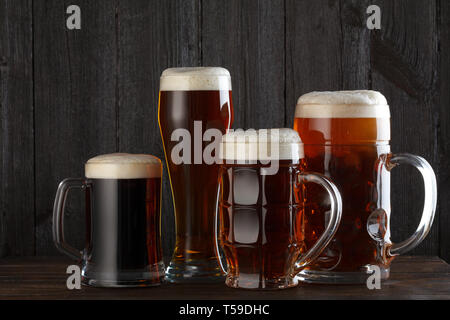 Biergläser mit Lagerbier, dunkles Bier, Ale, Stout Bier am Tisch, dunklen Hintergrund Stockfoto