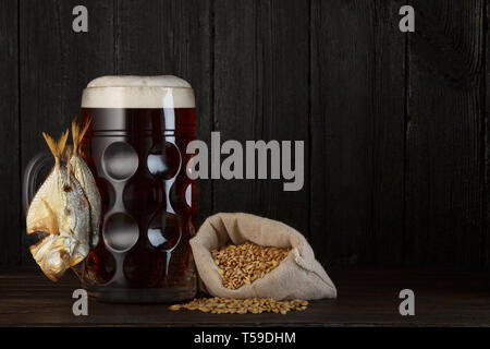 Bierkrug mit geräuchertem gesalzener Fisch Snack und Tasche von Gerste Stockfoto