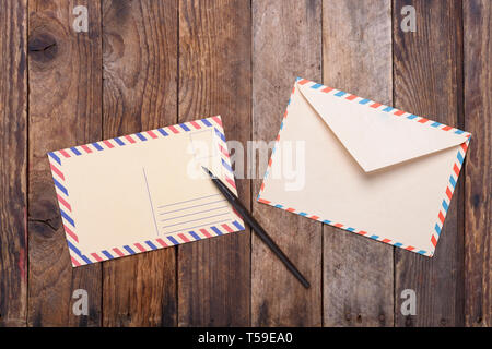 Postkarte mit Füllfederhalter ende Umschlag auf alten Holztisch Stockfoto