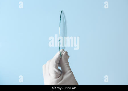 Neue Funktionen von Glas Forschung, Hand in Hand holding Kreis Stück transparentes Material Stockfoto