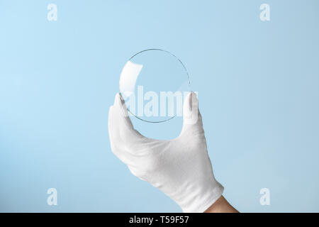 Neue Funktionen aus Glas oder Kunststoff, Forschung, Hand in Hand holding Kreis Stück transparentes Material Stockfoto