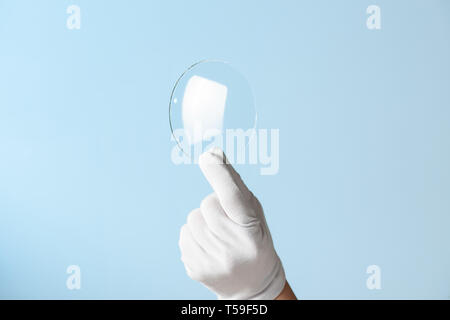 Neue Funktionen aus Glas oder Kunststoff, Forschung, Hand in Hand holding Kreis Stück transparentes Material Stockfoto