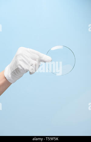 Neue Funktionen von Glas oder Kunststoff, Forschung, Hand in Hand holding Kreis Stück transparentes Material Stockfoto