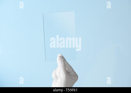 Neue Funktionen von Glas oder Kunststoff, Forschung, Hand in Hand Holding rechteckiges Stück transparentes Material Stockfoto