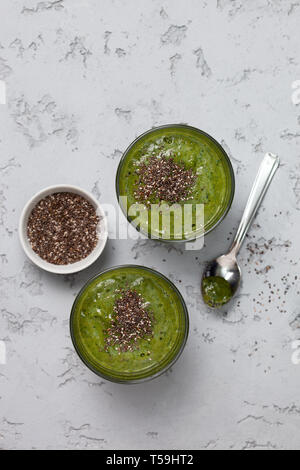 Grüne Smoothie in Gläsern auf einem grauen Hintergrund. Blick von oben. Kopieren Sie Platz Stockfoto