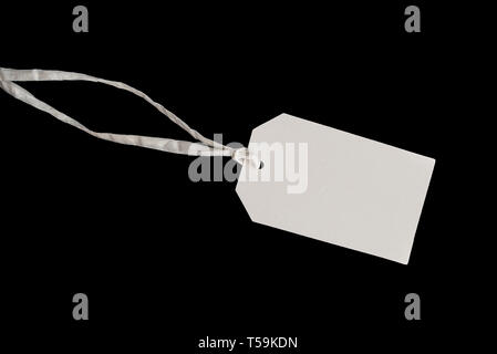 Leere weiße hängen tag Karton lable mit String auf schwarzem Hintergrund befestigt Stockfoto