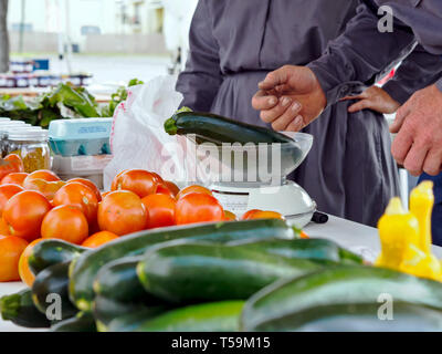 Zucchini Squash auf einem mechanischen Skala an der Corpus Christi Southside Bauernmarkt in Corpus Christi, Texas USA gewogen. Stockfoto