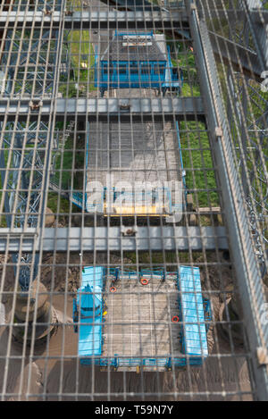 Die Gondel, unten, das hängt von der Newport Transporter Bridge, South Wales ist über den Gehweg Gitter auf den Brücken sichtbare Gantry Stockfoto